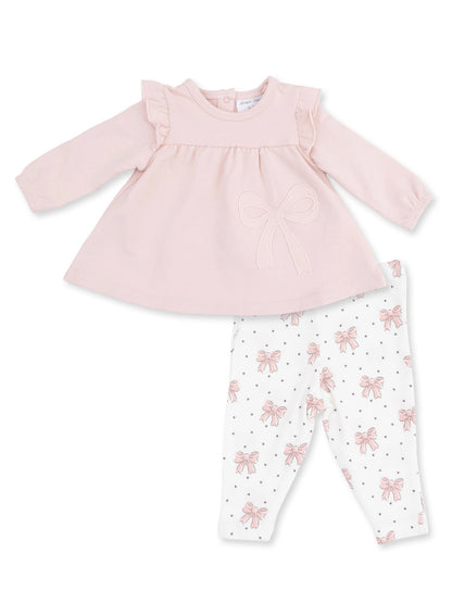 Pink long-sleeve shirt with ruffles and bow, paired with white leggings featuring pink bows and black polka dots.