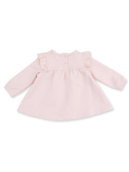 Light pink toddler dress with long sleeves and ruffled shoulders, featuring button closure at the back.