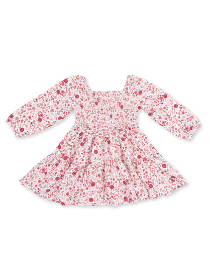 Floral long-sleeve dress with smocked bodice and gathered skirt, featuring pink and red flower patterns on a white background.