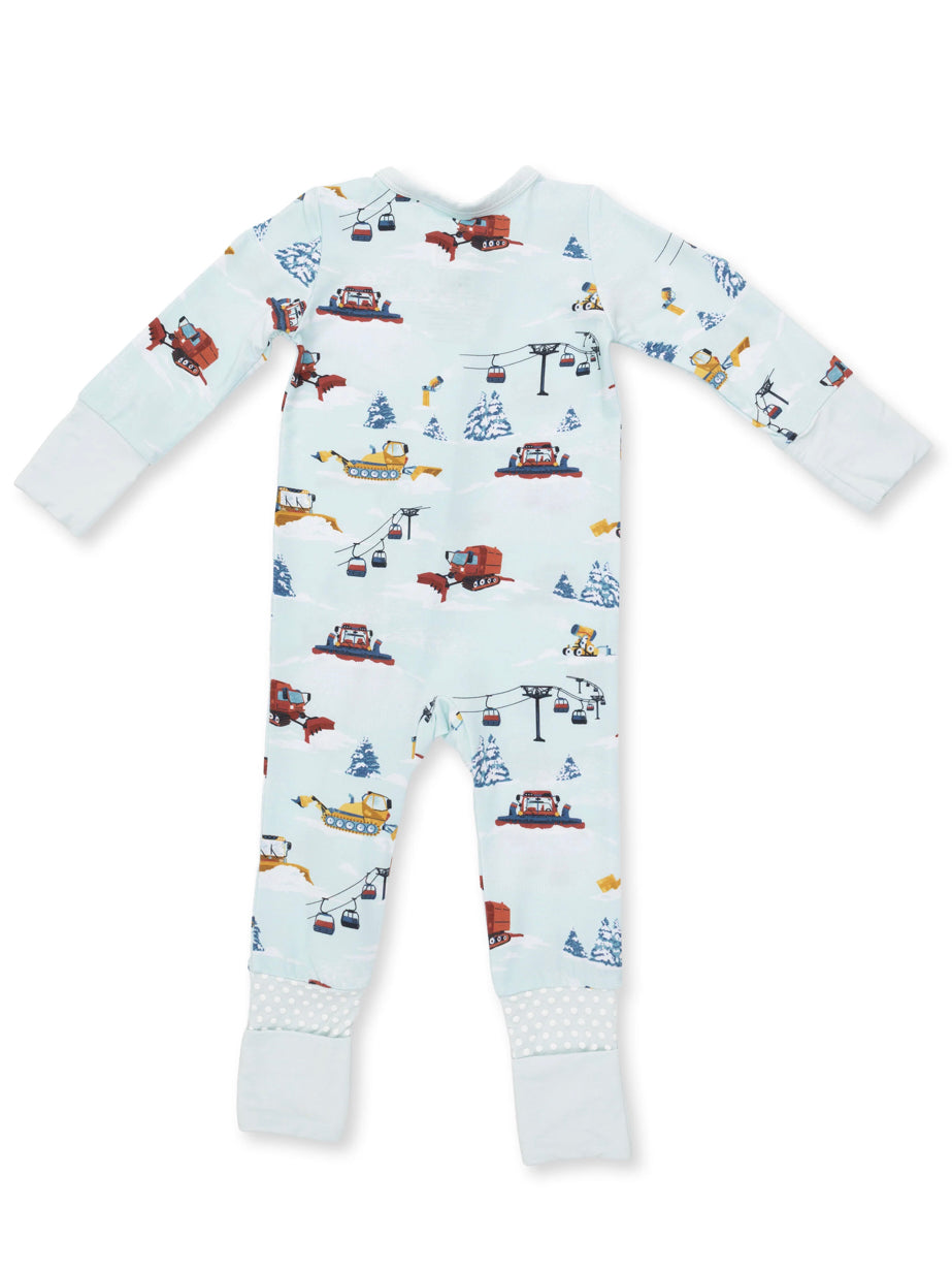 Pajamas with a playful winter scene featuring snow vehicles, trees, and ski lifts on a light blue background.