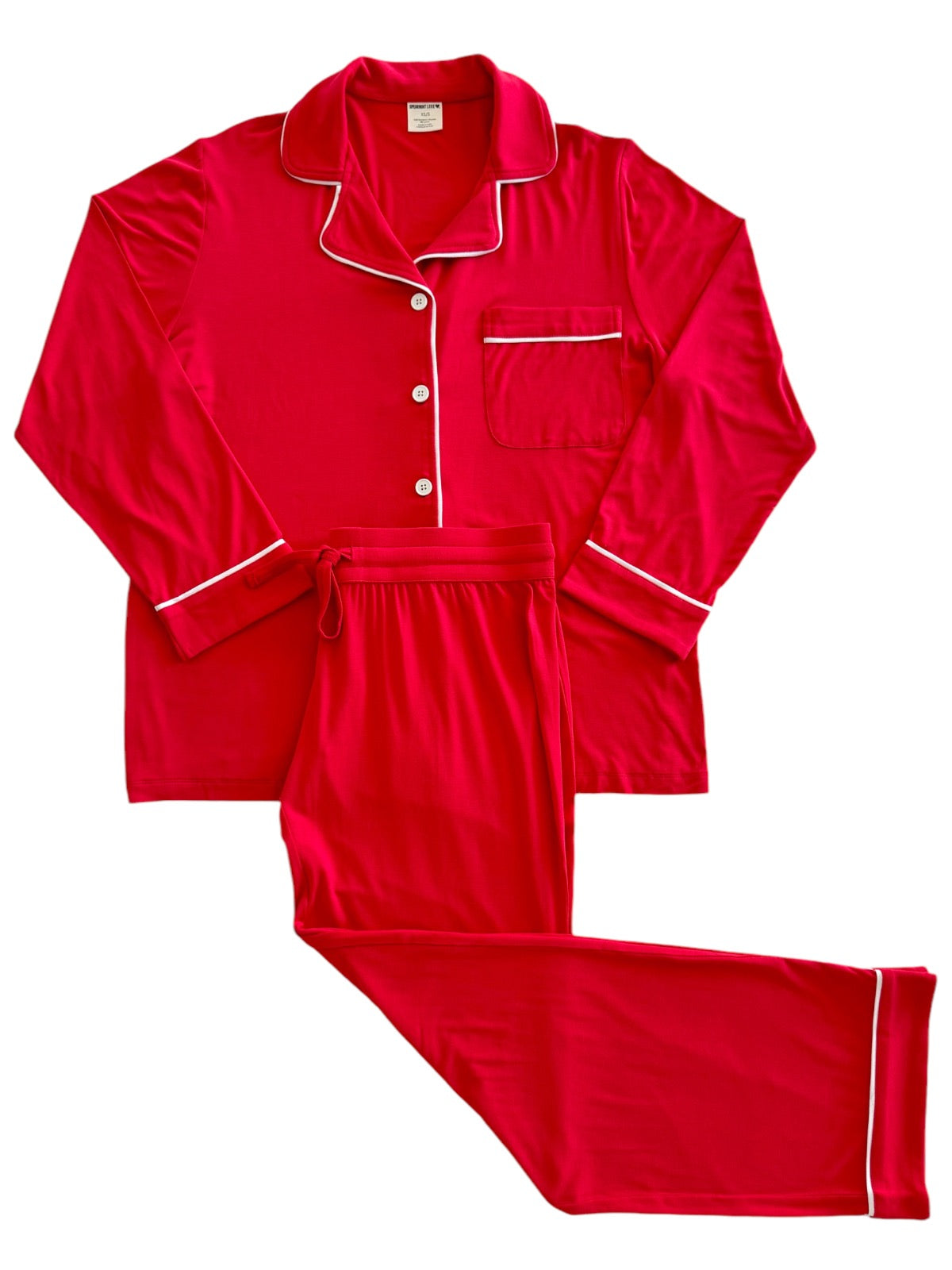 Red pajama set with long sleeves and pants, featuring white piping and a front pocket.