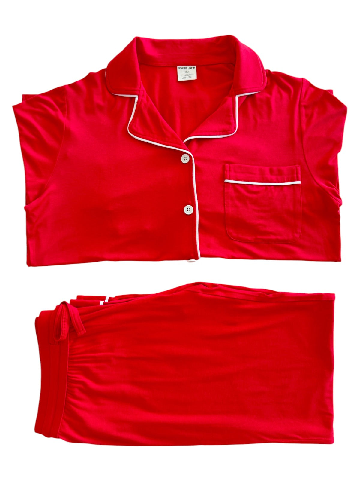 Red women's pajama set featuring a button-up top and matching pants, laid flat on a white background.
