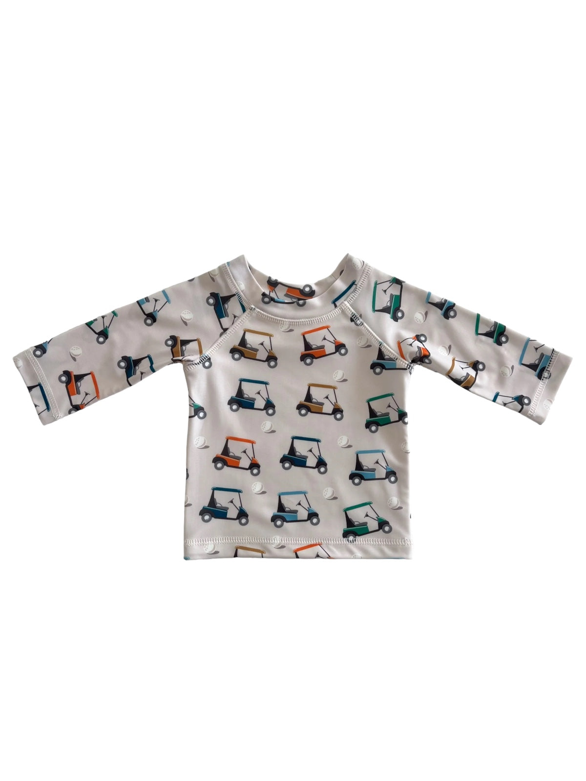 Children's long-sleeve shirt featuring a playful golf cart print on a light-colored background.