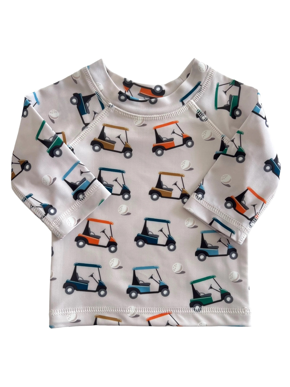 Children's long-sleeve shirt featuring a playful golf cart print on a white background.