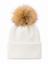 White beanie hat with a large tan fur pom-pom on top, featuring a cuffed design.