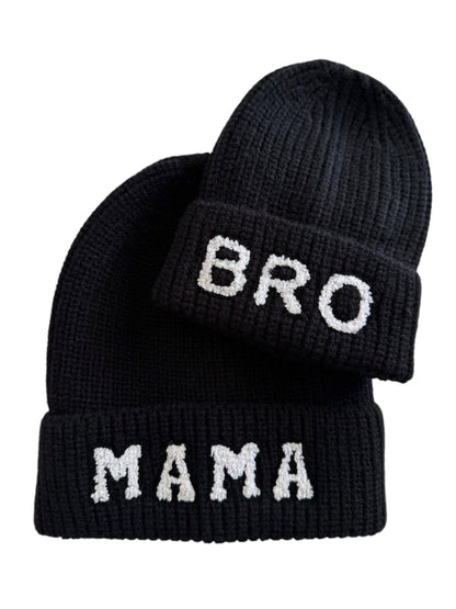 Two black knitted beanies with the words "MAMA" and "BRO" in white letters.