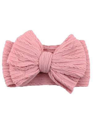 Pink fabric headband with a large bow and textured design, ideal for children's accessories.