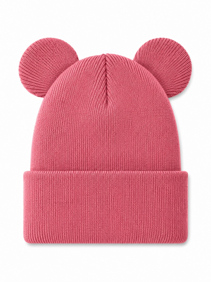Pink beanie hat with rounded ears, featuring a ribbed knit design and folded cuff, laid flat on a white background.
