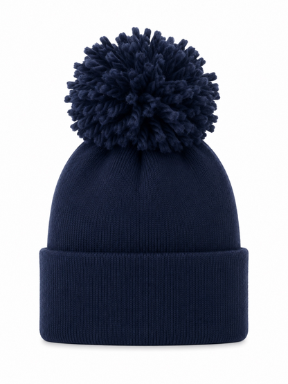 Navy knitted beanie with a large fluffy pom-pom on top and a folded brim.