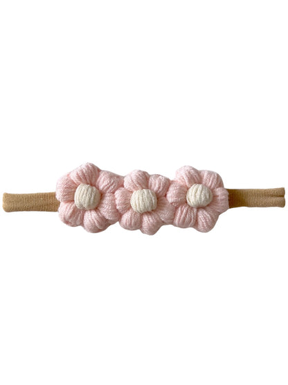 Pink flower hairband with three fabric flowers and a tan elastic strap. Ideal for children’s hair accessories.