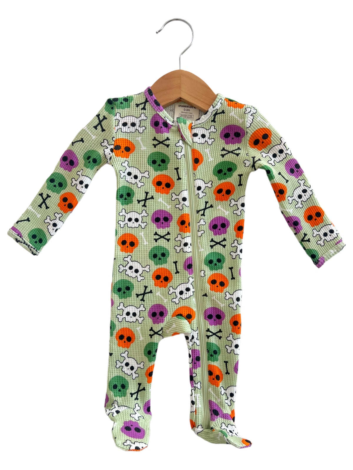 Green zip-up onesie with colorful skulls and bones pattern, suitable for children.