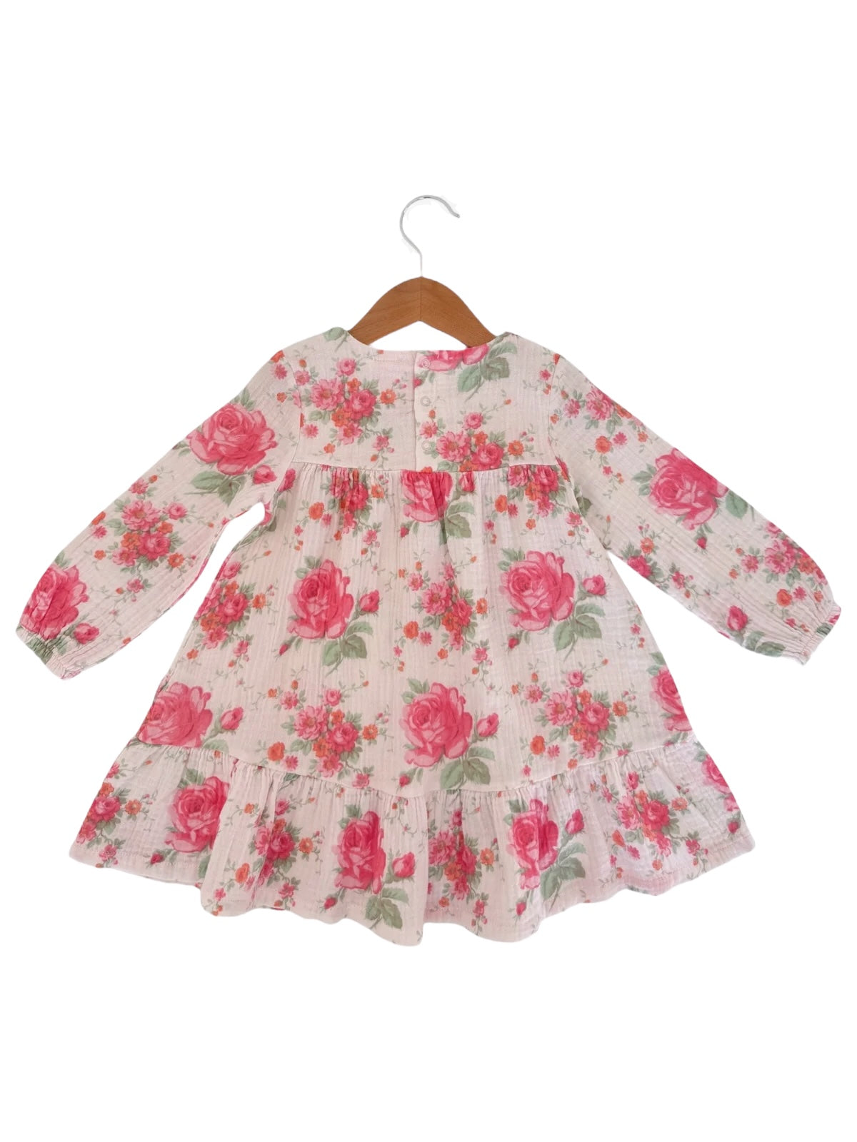 Floral dress with long sleeves, pink roses on a light background, hanging on a wooden hanger.