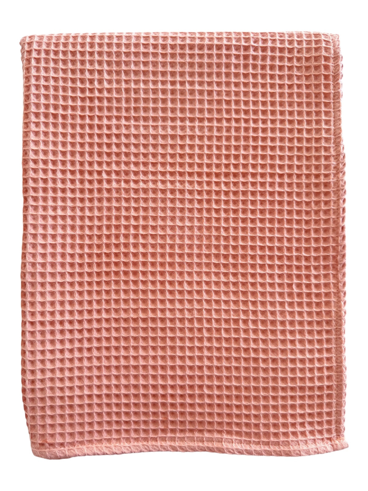 Peach-colored waffle-textured fabric folded neatly on a white background.