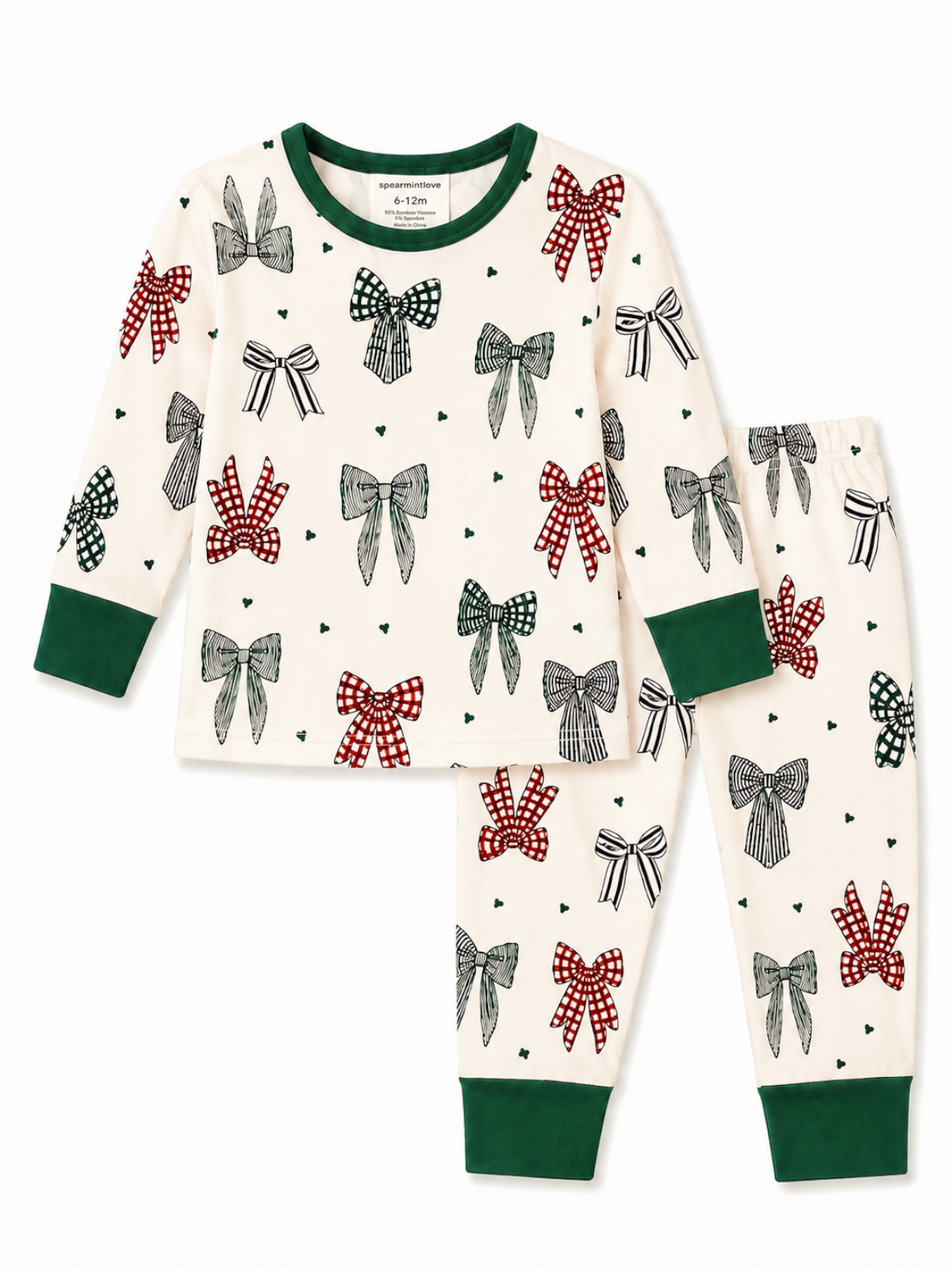 Children's pajama set featuring a cream color with assorted bows in red, green, and black on a white background.