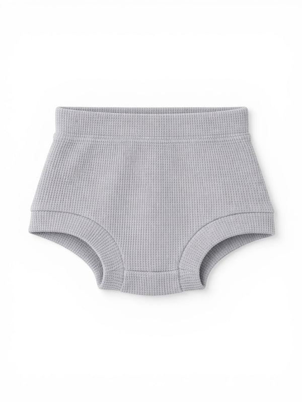 Gray waffle-knit baby shorts with a soft elastic waistband. Ideal for comfort and style.