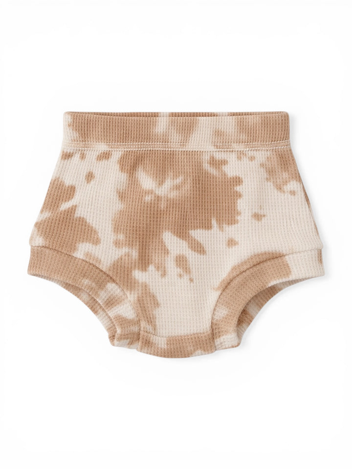 Tan tie-dye children's underwear on a white background. Soft, ribbed texture with elastic waistband.