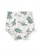 White fabric diaper cover with green cactus patterns and ruffled edges.