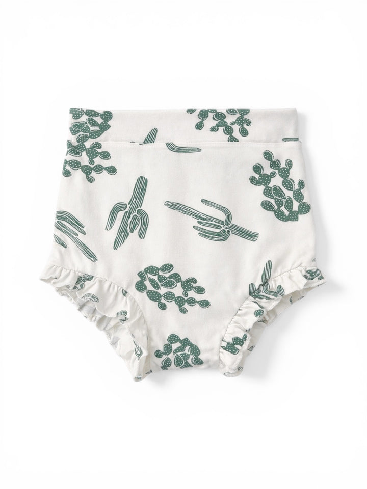 White fabric diaper cover with green cactus patterns and ruffled edges.