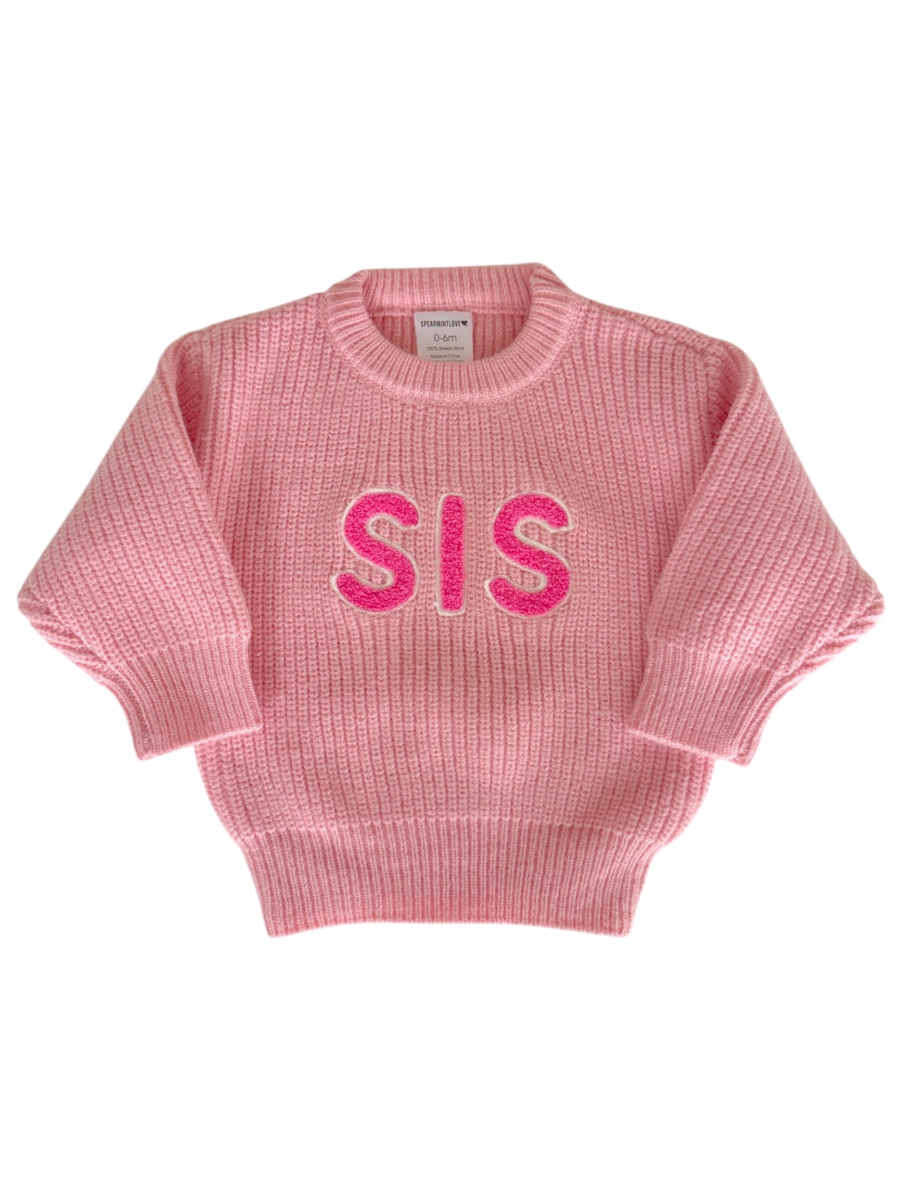 Pink knitted sweater with "SIS" in bright pink letters on the front, designed for infants and toddlers.