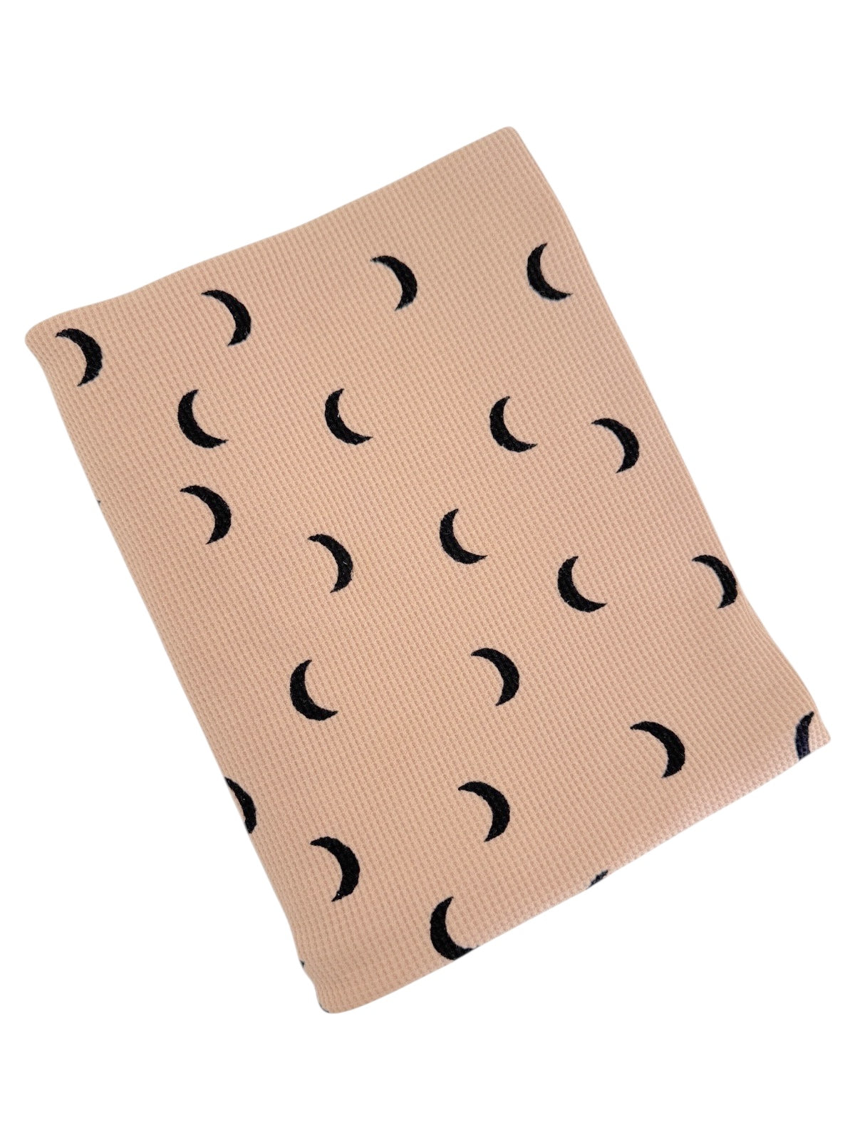 Neutral-toned fabric with black crescent moon patterns, folded neatly. Ideal for aesthetic decor or fashion.