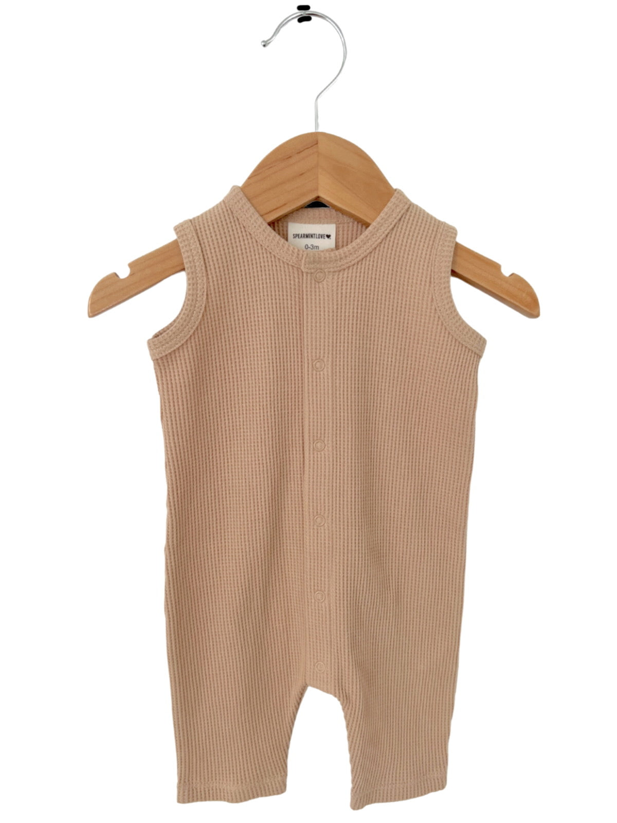 Beige sleeveless baby romper on a wooden hanger, featuring a ribbed texture and button closure.