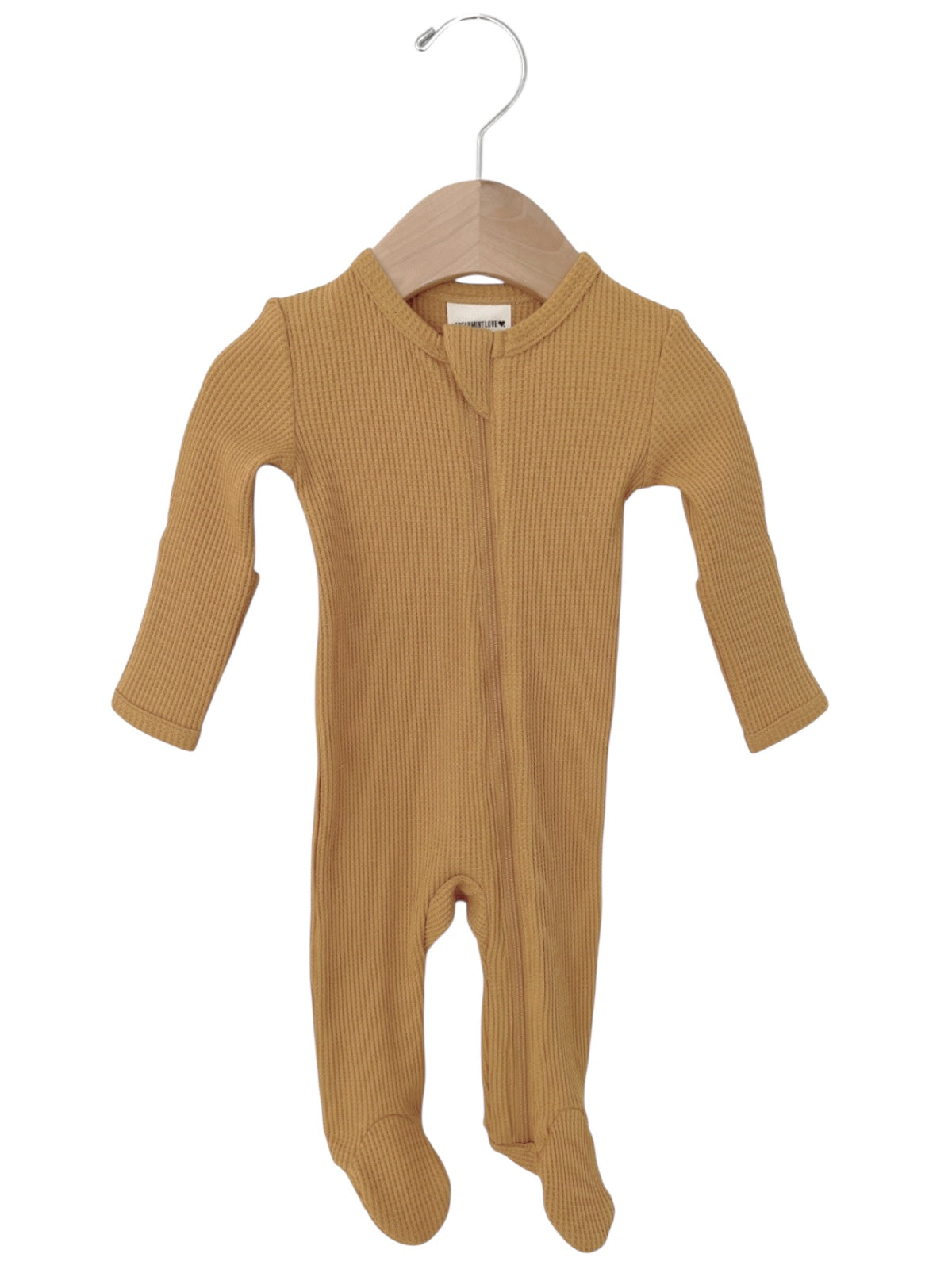 Yellow ribbed baby onesie hanging on a wooden hanger, featuring long sleeves and footed bottoms.