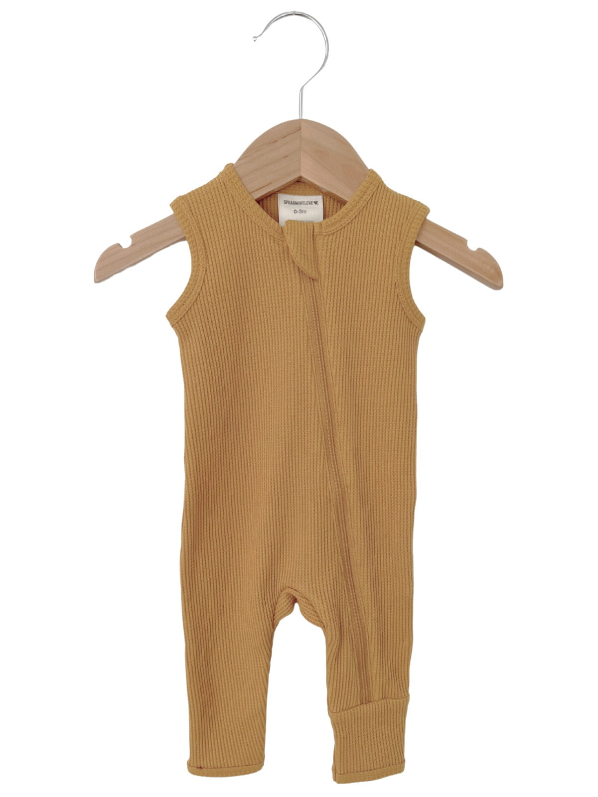 Mustard-colored infant onesie on a wooden hanger, featuring a zipper and ribbed texture. Ideal for ages 0-3 months.