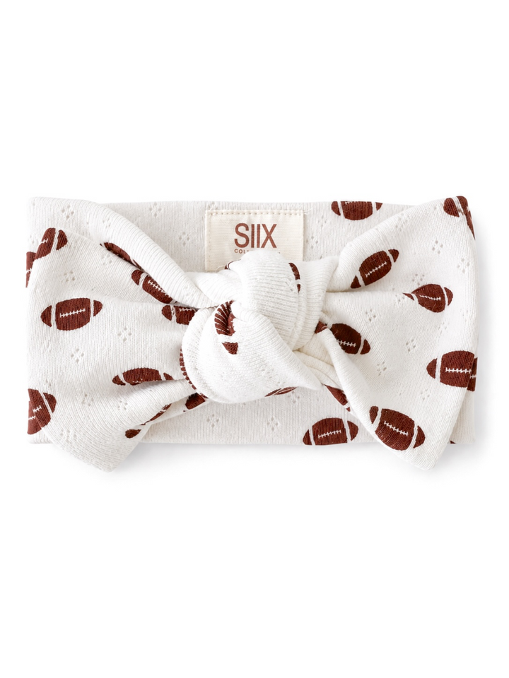 White headband with football pattern and knot detail, labeled with brand SIIX.
