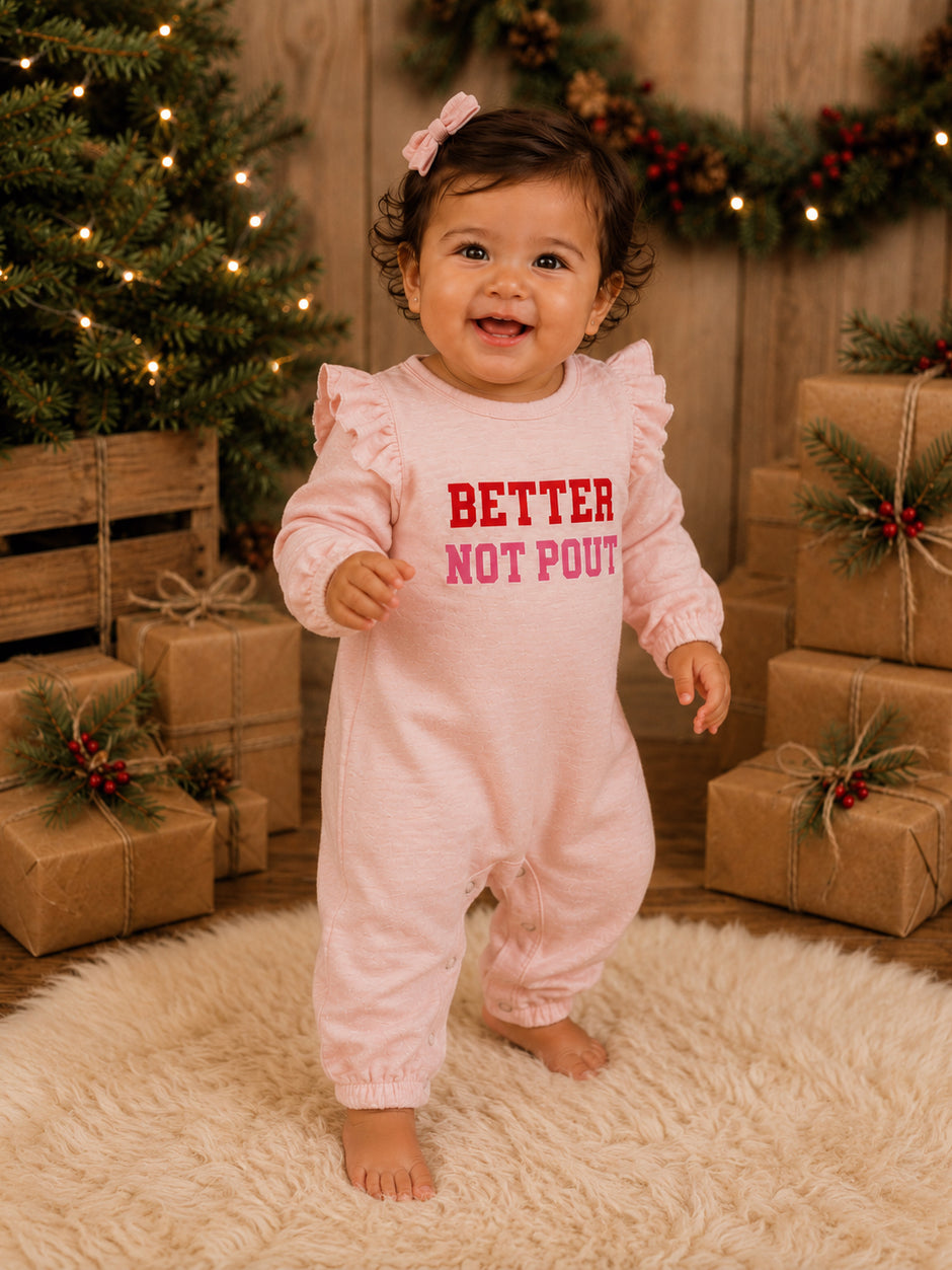 Smiling baby in pink outfit with "Better Not Pout" text, surrounded by holiday decorations and gift boxes.