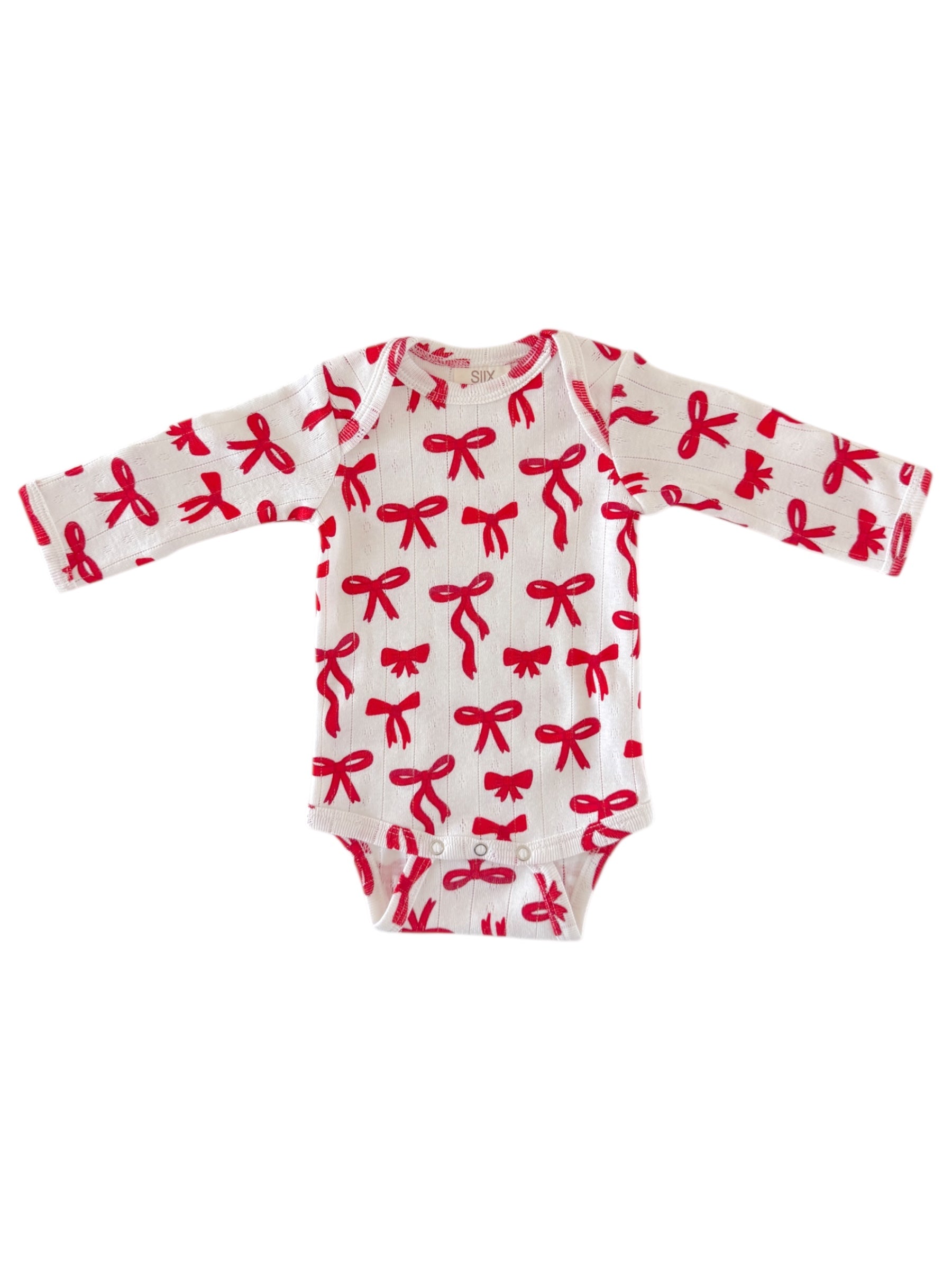 White baby bodysuit with red bow patterns and long sleeves. Ideal for infants and toddlers.