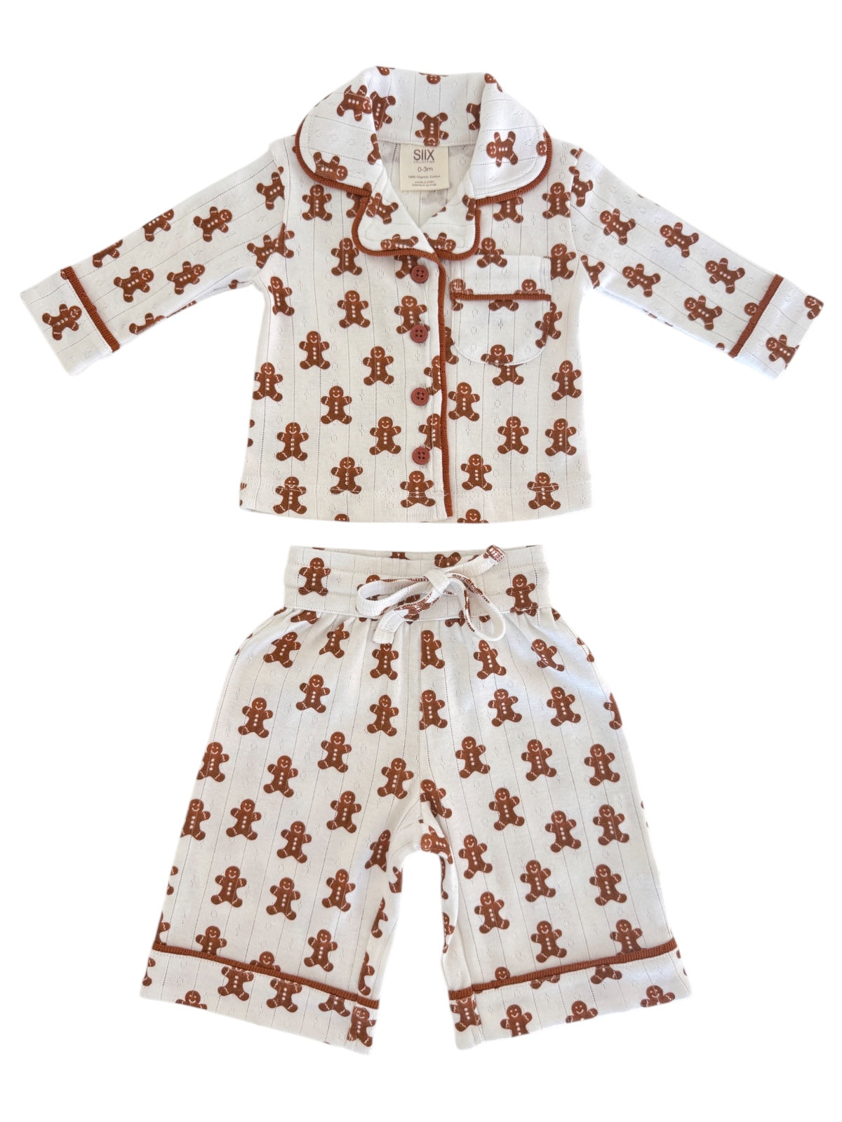 Gingerbread-themed children's pajama set with a collared top and shorts, featuring playful patterns.