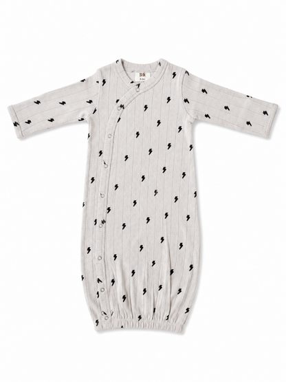 Light gray baby gown with black lightning bolt patterns and snap buttons along the side, suitable for newborns.