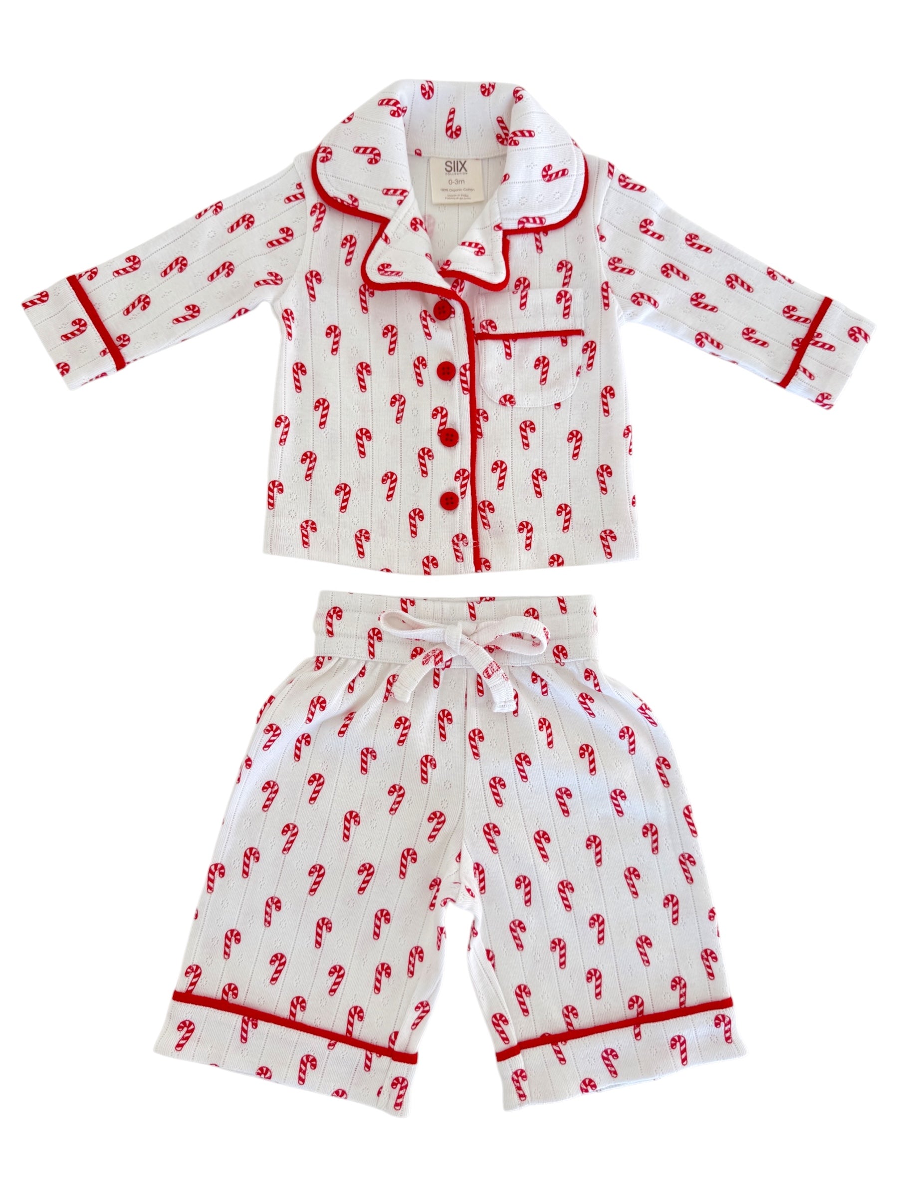 Children's pajamas with red candy cane pattern on white fabric, featuring a collared shirt and matching pants.