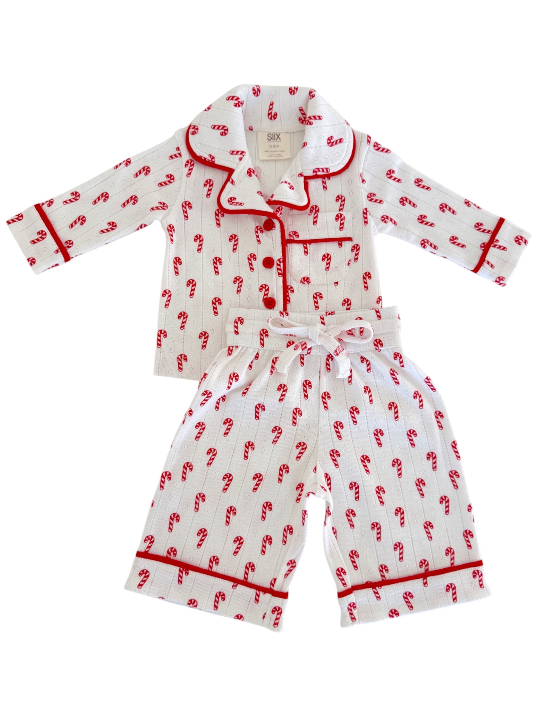 White pajama set with red candy cane design, featuring a collar and contrasting trim.