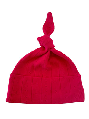 Bright pink knitted hat with a knot at the top and textured pattern. Ideal for stylish warmth.