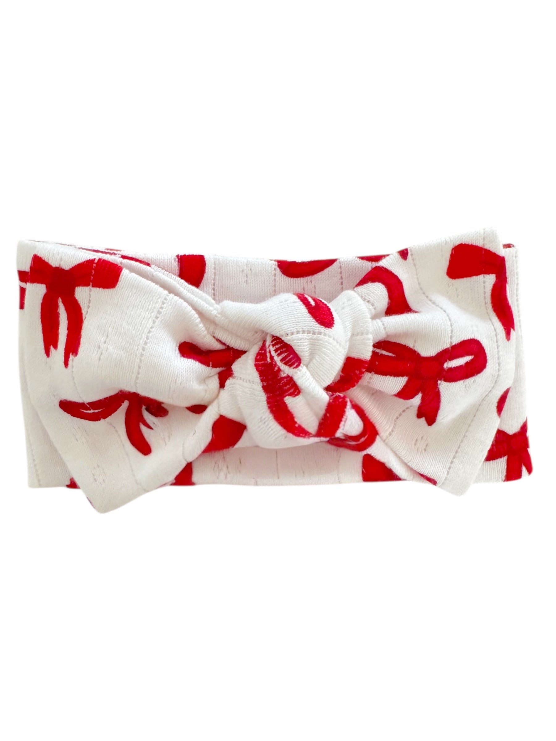 White headband with red ribbon patterns and a knot in the center, perfect for stylish hair accessories.