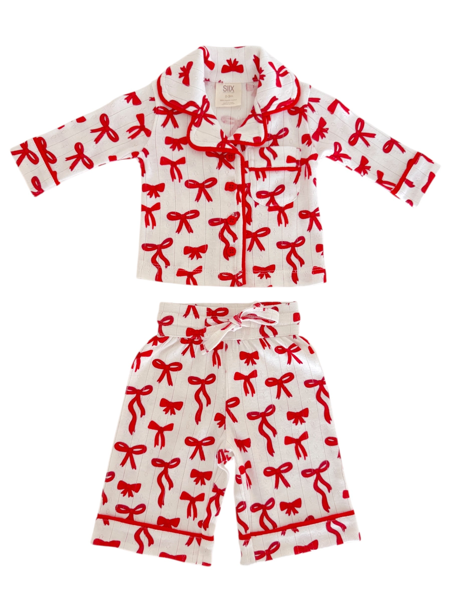Children's pajama set featuring a white fabric adorned with red bow patterns. Soft and cozy design for bedtime.