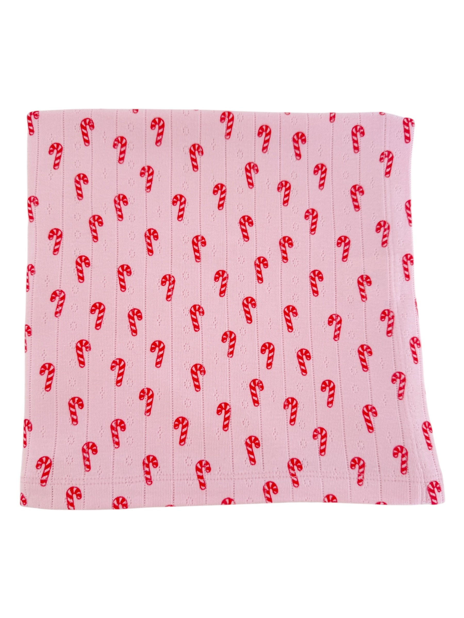 Pink fabric with a repeated candy cane pattern in red and white. Ideal for holiday-themed projects or decor.