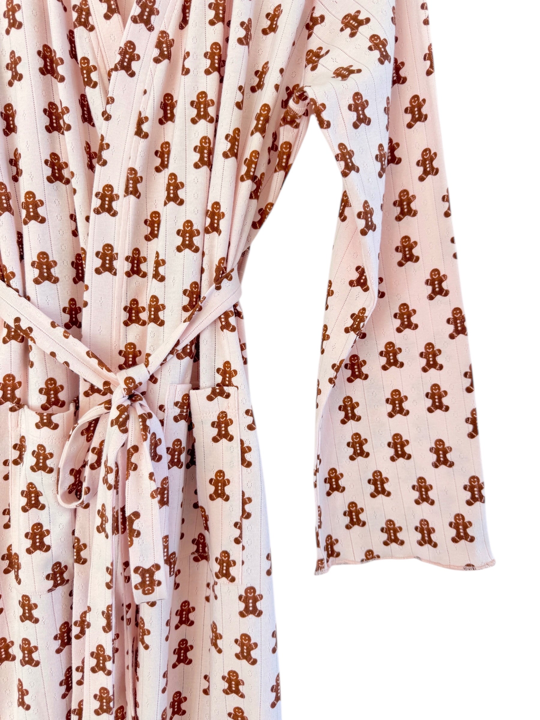 Pink robe with gingerbread man pattern, featuring long sleeves and a tied waist.