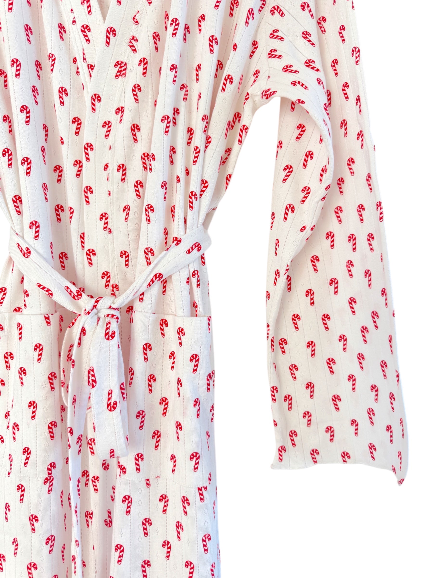 White bathrobe with red candy cane pattern, tied at the waist, featuring long sleeves and front pockets.