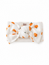 White headband with orange pumpkin print and a knot at the center, brand label visible on the back.
