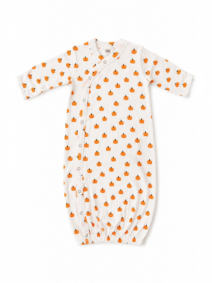 White baby gown with orange pumpkin pattern and snap buttons, perfect for fall festivities.