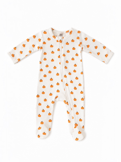 White baby sleeper with orange pumpkin pattern, featuring long sleeves and footed design. Perfect for fall.
