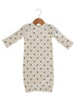 Cream dress with long sleeves and black heart patterns, hanging on a wooden hanger.