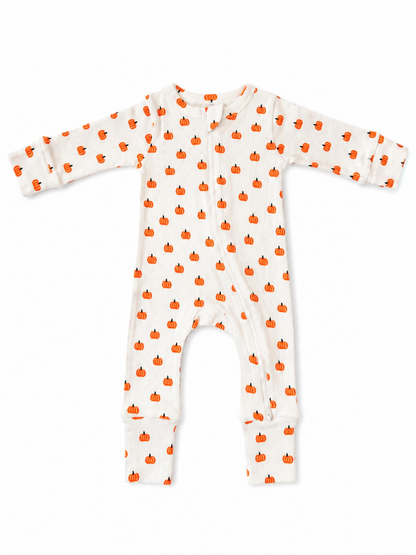 White baby pajamas with orange pumpkin pattern, featuring long sleeves and footed design.