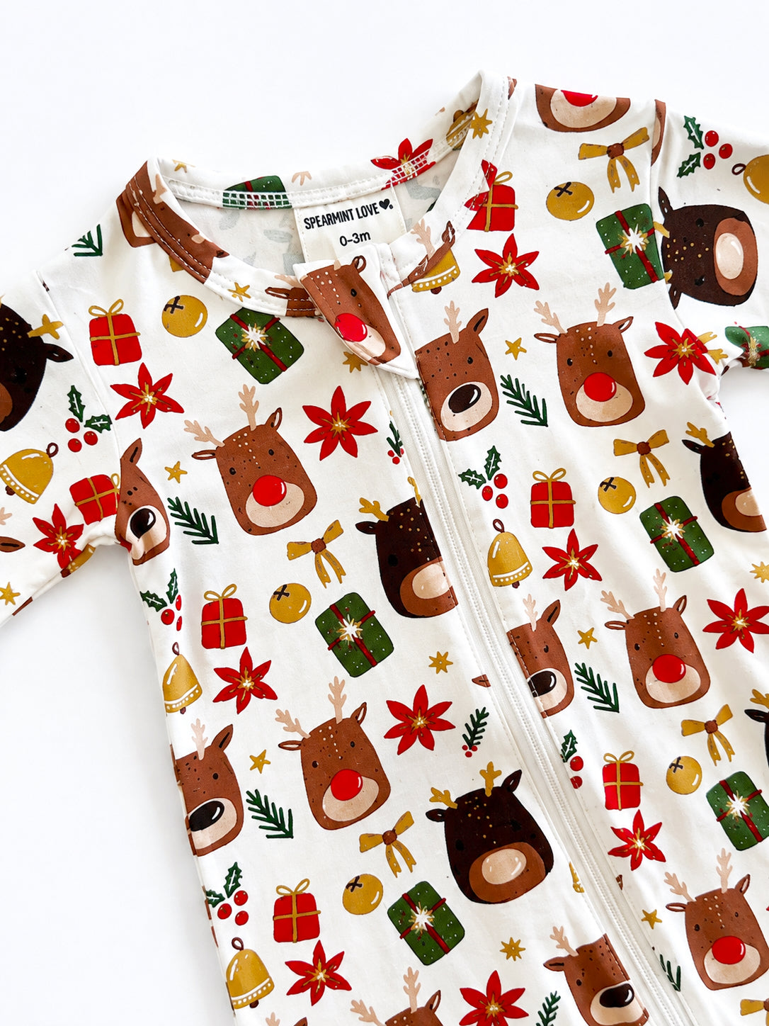 Baby onesie with a festive reindeer and holiday pattern featuring gifts, stars, and bells on a light background.