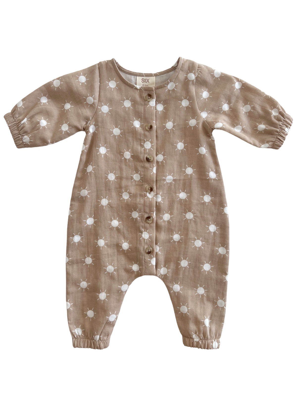 Light brown baby onesie with white sun patterns and button front, featuring elastic cuffs and cozy fabric.