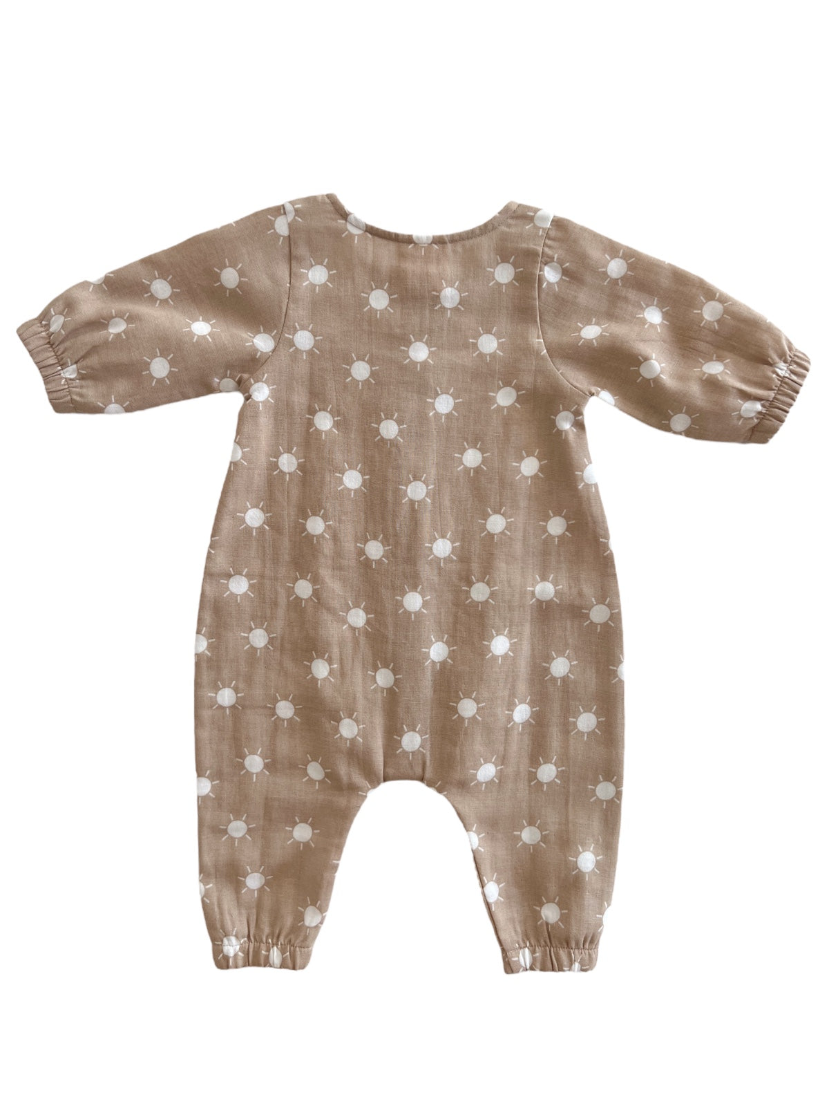 Tan baby romper with white sun patterns, featuring puffed sleeves and elastic cuffs, displayed on a white background.