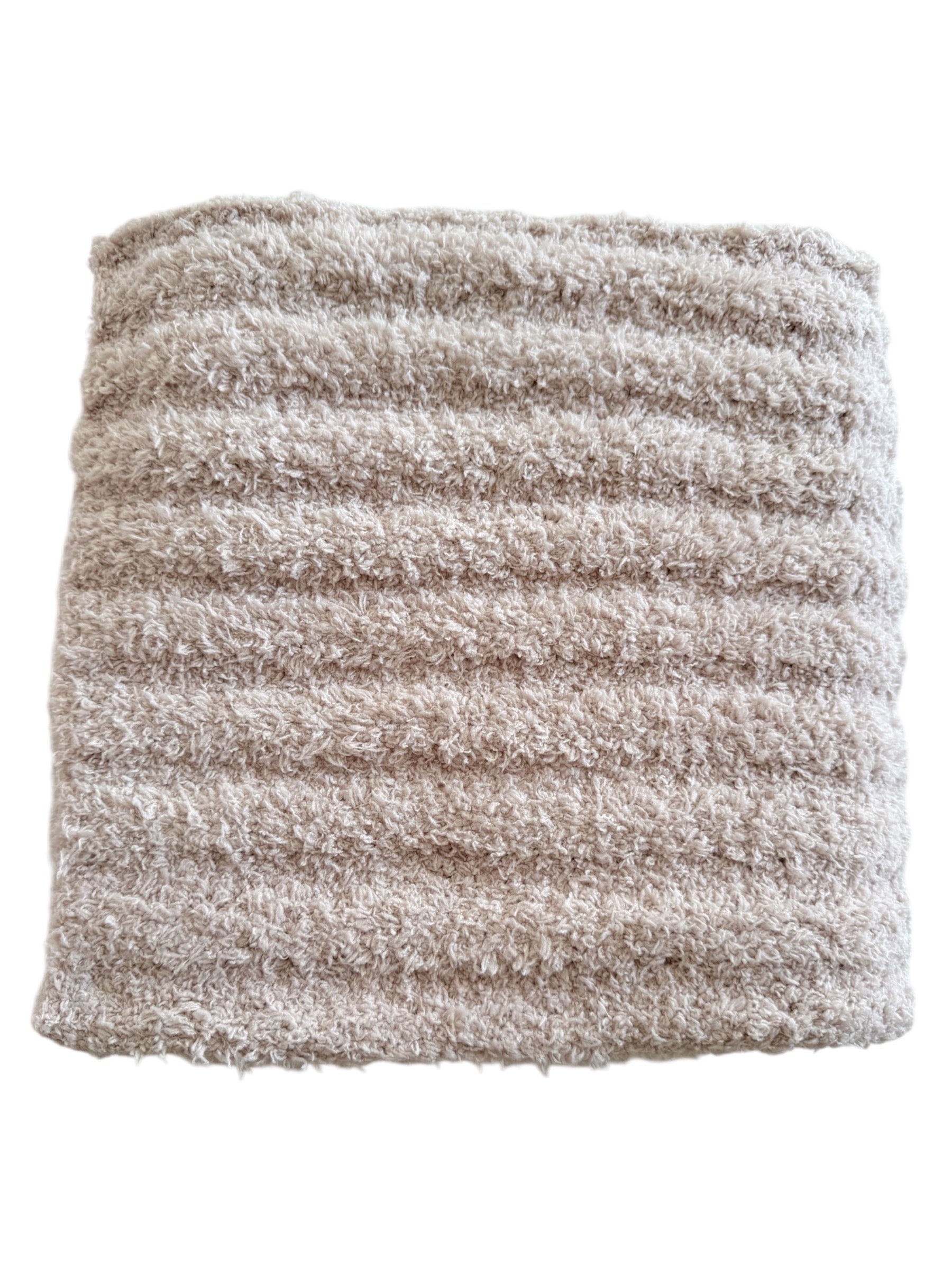 Beige towel with textured stripes, folded neatly for display. Ideal for bath or spa use.