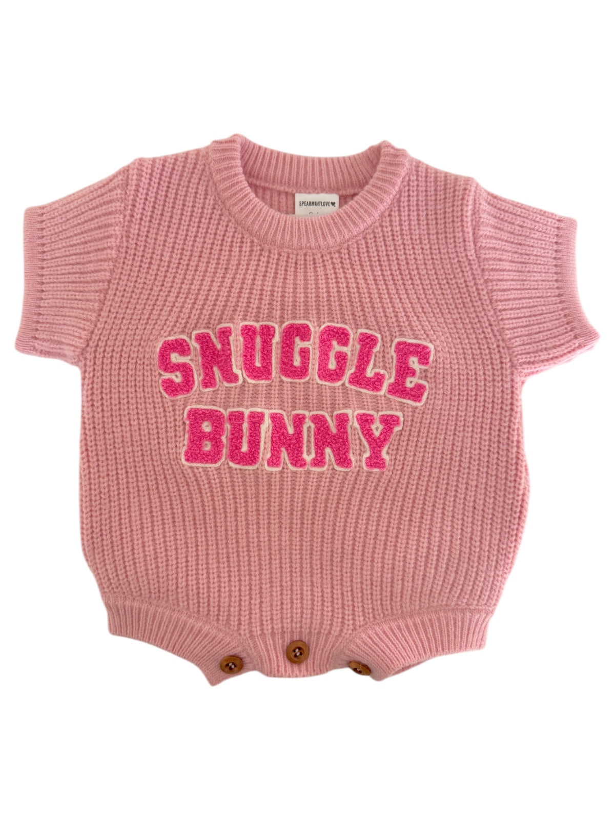 Pink knit baby onesie with "Snuggle Bunny" text in bold, playful letters. Ideal for cozy occasions.